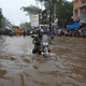 A man rides his motorbike through a water-logged road in Mumbai.